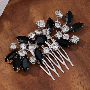 Macro shot of vintage silver hair comb with black and clear rhinestones on dark wood