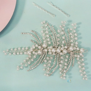 Exquisite bridal hair vine with pearls and crystals on a light blue background