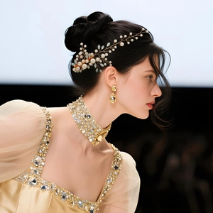 Vue détaillée de pinces à cheveux en fil d'or avec perles blanches et cristaux sur cheveux
