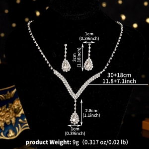 Detailed view of silver crystal bridal necklace and teardrop earrings on black velvet