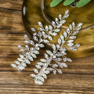 Detail der Brauthaarklammer in Silberblatt-Optik mit Perlen auf dunklem Holztisch