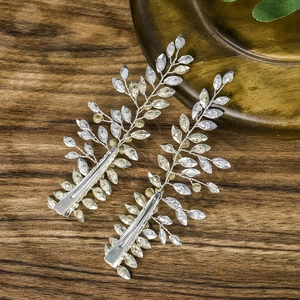 Detail von silbernen Braut-Haarklammern mit Kristallen auf dunklem Holzgrund