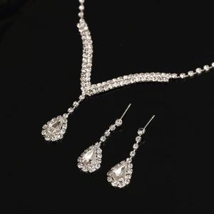 Detailed close-up of bridal necklace and drop earrings with sparkling rhinestones