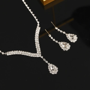 Detailed close-up of bridal necklace and drop earrings with sparkling rhinestones