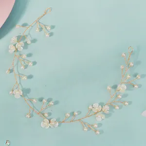 Détail macro du bandeau de mariée avec perles blanches et fleurs dorées faites main
