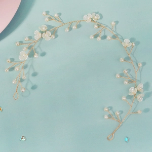 Détail de la vigne de cheveux de mariée avec fil doré, perles et petites fleurs blanches