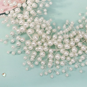 Detailed shot of handmade bridal headband with white pearls and silver wire floral branches