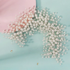 Handmade bridal hair vine with white pearls and silver wire on a romantic pastel background
