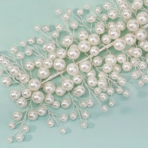 Close-up of bridal headband with handmade silver wires and white faux pearls in branch shape