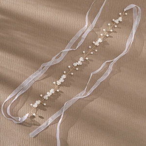 Détail de bandeau de mariée avec perles, vigne en fil doré et rubans en organza