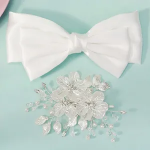 White bridal bow clip and handmade flower hair pin set on light blue background