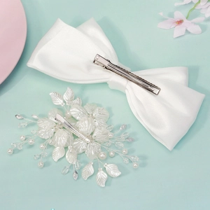 Elegant white oversized bridal bow and floral hair clip set with pearls on blue background