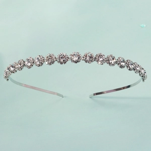 Détail d'un serre-tête en métal argenté orné de grappes de cristaux de zircon blancs