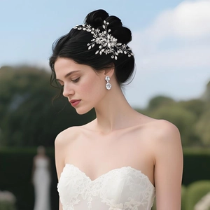 Detail view of silver floral bridal hair pin and matching drop earrings with pearls