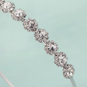 Détail du serre-tête argenté avec des strass étincelants en forme de tournesol