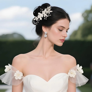 Detail of white ceramic flower bridal hair comb and geometric earrings on a bride