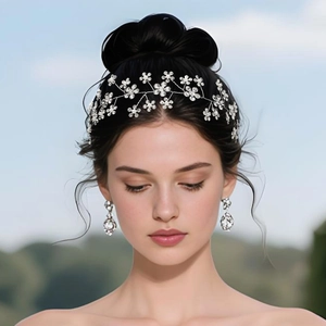 Detail of floral bridal headpiece and teardrop earrings set on a model in nature