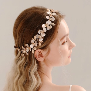Detalle de la diadema de novia con hojas de metal dorado y perlas florales crema