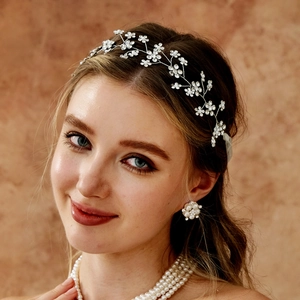 Détail de parure de mariée avec serre-tête fleuri en strass et collier de perles