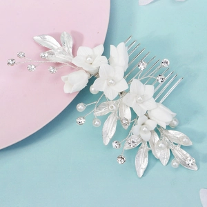 Detailed close-up of handmade bridal hair comb with white ceramic flowers and pearls