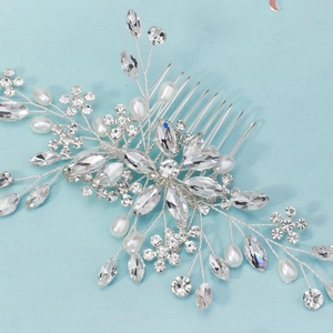Macro view of handmade silver bridal hair comb with rhinestones and white teardrop pearls