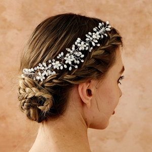 Détail d'une vigne de cheveux de mariée avec perles blanches et cristaux sur une coiffure