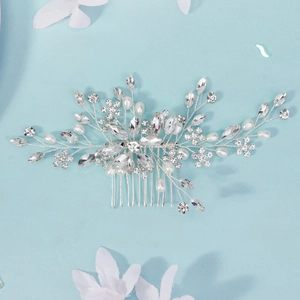 Macro detail of handmade bridal hair comb with rhinestones and white pearls on blue background