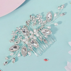 Macro shot of silver bridal hair comb with rhinestones and white pearls on blue background