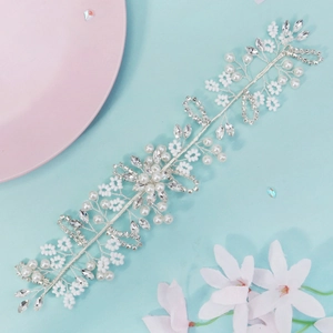 Detailed macro view of handmade bridal hair vine with white pearls and sparkling rhinestones
