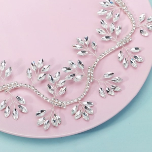 Close-up of a silver bridal hair vine with marquise rhinestones on a pink tray