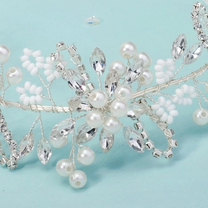 Close-up of handmade bridal headband with silver wire, white pearls and clear rhinestones
