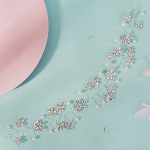 Detail of silver bridal hair vine with rhinestone flowers and white imitation pearls