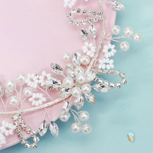 Close-up of handmade bridal headband featuring white pearls and crystal flower details