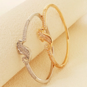 Detailed close-up of seahorse-shaped bangles with cubic zirconia pavé setting accents