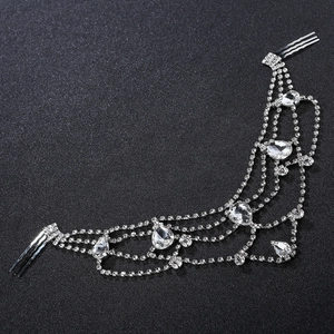 Detail of silver rhinestone bridal headpiece with teardrop crystals on black background