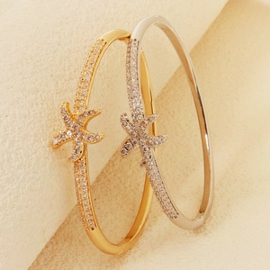 Detailed view of starfish bracelets in gold and silver finish with pavé set cubic zirconia