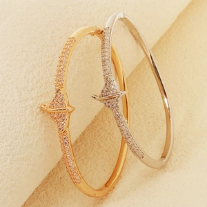 Detail view of gold and silver bangle set with sparkling star-shaped zircon pavé stones