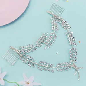 Close-up of bridal rhinestone hair band with silver leaf motifs and metal combs
