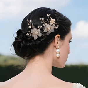 Detail of bridal hairpins and pearl earrings with golden wire flowers and crystal beads