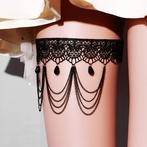 Détail d'une jarretière gothique en dentelle noire avec perles et chaînes multicouches