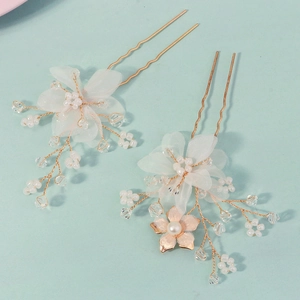 Detailed close-up of handmade bridal flower hair pins with pearls and gold wire