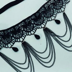 Vue détaillée d'une jarretière en dentelle noire avec chaînes et perles en métal
