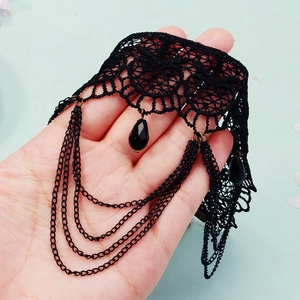 Détail de l'anneau de cuisse gothique en dentelle noire avec perles et chaînes en métal suspendues