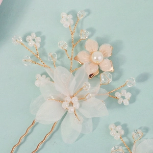 Detail of handmade bridal hair pin with white mesh flowers and delicate gold wire pearls