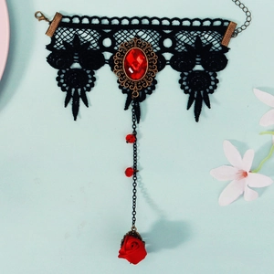 Detail of gothic black lace hand harness with red gemstone and rose pendant