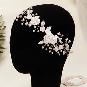 Elegant bridal hair band with white ceramic flowers, silver leaves, and pearls for weddings