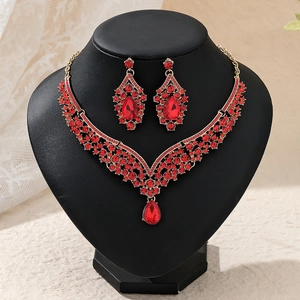Detail eines luxuriösen Brautschmuck-Sets mit roten birnenförmigen Steinen und Goldkette