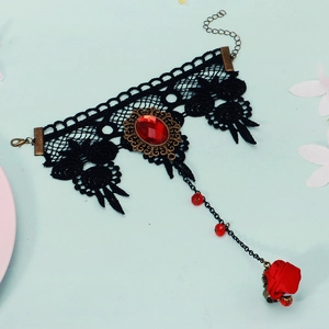 Close-up of gothic black lace necklace with a red gemstone and 3D fabric rose detail