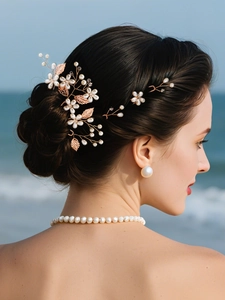 Detail of bridal hair vine set with pearls and rose gold leaves on beach background