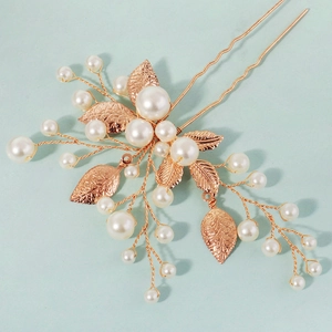 Detail view of handmade bridal hair pins with golden leaves and white pearls decoration